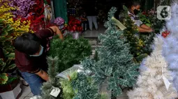 Para pedagang marapikan replika pohon Natal di Pasar Asemka, Jakarta, Rabu (16/12/2020). Pernak-pernik yang dijual di Pasar Asemka ini sangat lengkap yang dijual dimulai dengan harga Rp20.000 hingga Rp15,9 juta. (Liputan6.com/Johan Tallo)