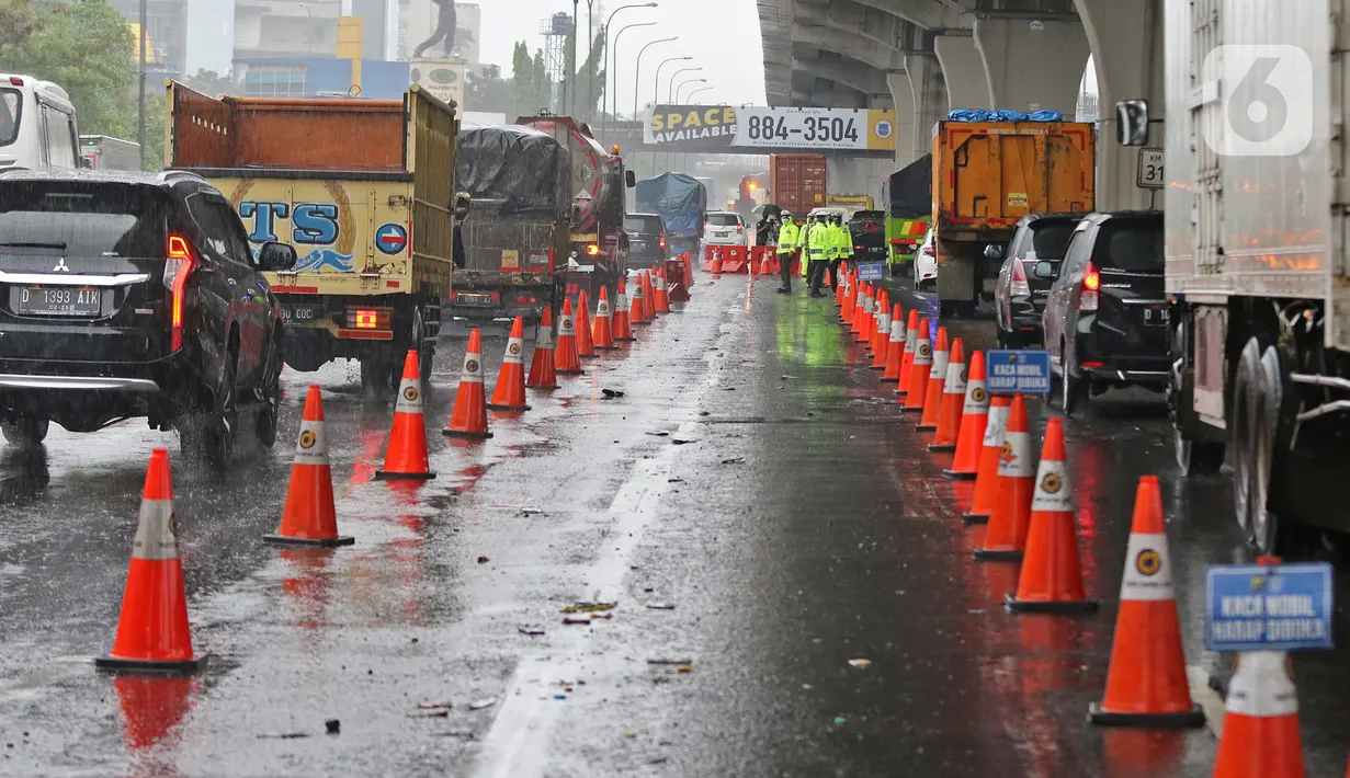 Petugas kepolisian berjaga di Pos Penyekatan Jalur Mudik di Gerbang Tol Cikarang Barat, Kabupaten Bekasi, Senin (18/5). Memasuki H-6 Lebaran, puluhan kendaraan diminta untuk putar balik karena melanggar larangan mudik sebagai upaya memutus rantai penyebaran Covid-19. (Liputan6.com/Herman Zakharia)