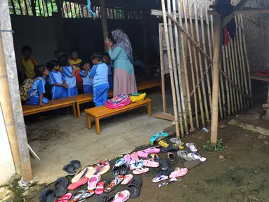 Seorang ibu melihat aktivitas belajar mengajar di Pendidikan Usia Dini (PAUD) Pelopor di Desa Cibeuteung, Ciseeng, Bogor, Rabu (19/2/2020). Sudah sejak 2009, PAUD yang memiliki 30 murid ini belajar pada bangunan sederhana menumpang di tanah milik orang lain. (merdeka.com/Arie Basuki)