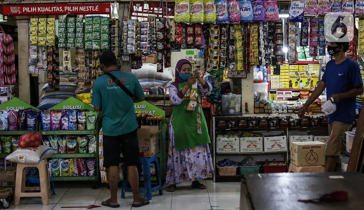 Pedagang menjaga toko sembakonya yang dipasang stiker sertifikat vaksin Covid-19 di Pasar Santa, Jakarta, Minggu (5/9/2021). Berbagai upaya dilakukan pedagang Pasar Santa untuk menarik pelanggan di masa PPKM level 3, salah satunya dengan memasang stiker sertifikat vaksin. (Liputan6.com/Johan Tallo)