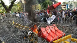 Sejumlah elemen mahasiswa menggelar demo dengan membakar pembatas jalan di kawasan Patung Kuda, Jakarta Pusat, Selasa (13/9/2022). Demo tersebut untuk menolak kebijakan pemerintah menaikkan harga bahan bakar minyak (BBM). (Liputan6.com/Johan Tallo)