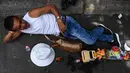 Seorang pria bersantai dengan mainannya saat merayakan Hari Malas Sedunia di Itagui, dekat Medellin, Kolombia, Minggu (18/8/2019). Kota Itagui dikenal karena perdagangannya ramai dan kawasan industri yang berkembang. (JOAQUIN SARMIENTO/AFP)