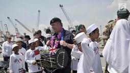 Kapten HMS Albion Tim Nield saat mencoba memainkan salah satu musik marawis di atas kapal perang HMS Albion di Pelabuhan Tanjung Priok, Jakarta, Minggu (22/4). (Merdeka.com/Iqbal S. Nugroho)