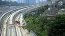 Pekerja menyelesaikan pembangunan LRT (Light Right Transit) Jabodebek di kawasan Kampung Makasar, Jakarta, Sabtu (26/10/2019). LRT akan diuji coba pada awal November 2019. (Liputan6.com/JohanTallo)