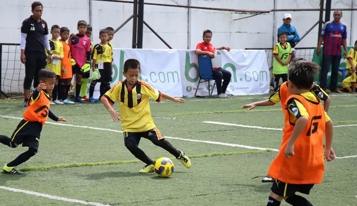 Seorang anak berusaha menggocek lawannya saat berlaga pada Liga Bola Indonesia. Pada kategori U-9, Bina Taruna masih menjadi pemuncak klasemen. (Bola.com/Vitalis Yogi Trisna)
