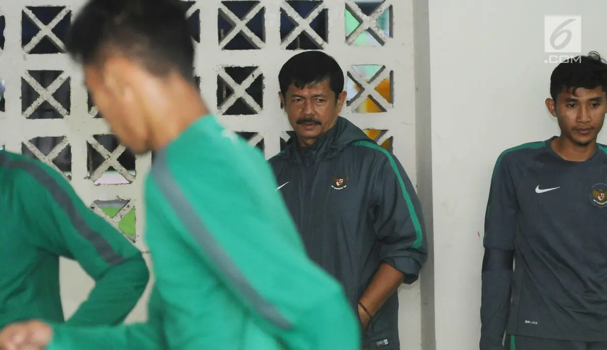 Pelatih Timnas Indonesia U-19, Indra Sjafri mengawasi latihan jelang laga persahabatan melawan Kamboja di Stadion Patriot Candrabhaga, Bekasi, Selasa (3/10). Timnas U-19 batal menggelar uji lapangan karena hujan deras. (Liputan6.com/Helmi Fithriansyah)