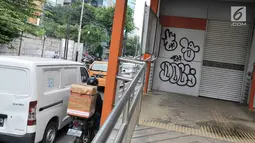 Coretan dengan cat semprot di bagian pintu masuk Halte Transjakarta Koridor 13, di Tendean, Jakarta, Senin (10/7). Coretan tersebut mengotori dan menimbulkan kesan kumuh serta tidak terawat. (Liputan6.com/Yoppy Renato)
