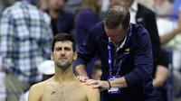 Novak Djokovic menjalani perawatan cedera bahu kiri saat menghadapi Stan Wawrinka di babak empat AS Terbuka 2019. (AFP/Matthew Stockman)