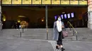 Komuter berjalan keluar dari Stasiun Flinders Street pada hari pertama wajib masker di tempat umum, di Melbourne, Kamis (23/7/2020). Penduduk kota terpadat kedua di Australia, Melbourne, diwajibkan mengenakan masker ketika meninggalkan rumah untuk mencegah penyebaran COVID-19. (William WEST/AFP)
