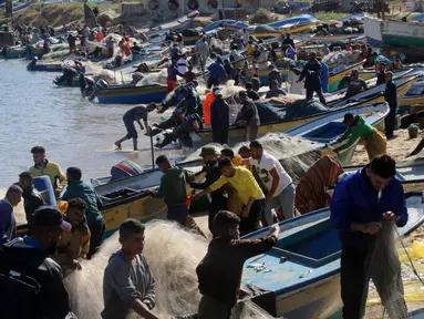 Sejumlah nelayan Palestina bekerja di pelabuhan di Gaza City (26/5/2020). Menurut data statistik resmi Palestina, ada sekitar 3.800 nelayan yang bekerja menggunakan 700 lebih perahu, sementara ada sekitar 70.000 orang yang mencari nafkah dengan menangkap atau menjual ikan. (Xinhua/Rizek Abdeljawad)