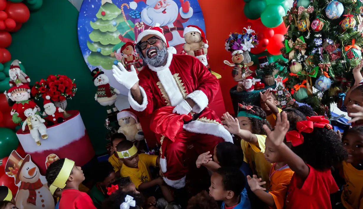 Black Santa membagikan buku anak-anak sebagai hadiah, memperkuat pentingnya pendidikan dan membaca, khususnya di kalangan anak-anak dan remaja. (AP Photo/Bruna Prado)