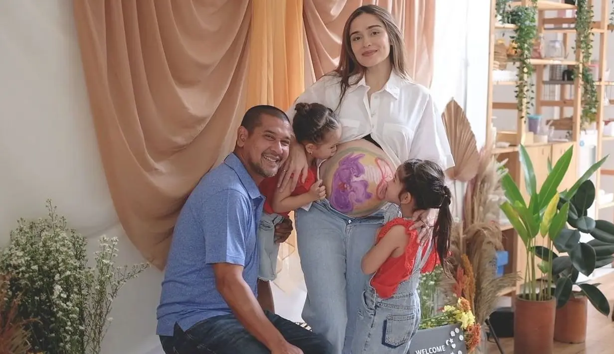 Yasmine Wildblood, berpose bersama keluarganya dengan perut besarnya yang telah digambar. (Foto: Instagram/@yaswildblood)