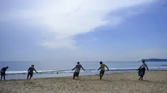 Para nelayan Sri Lanka menarik jaring ikan di pantai di Trincomalee (5/5). Trincomalee adalah kota pelabuhan di bagian timur Sri Lanka. (AFP Photo/Ishara S Kodikara)