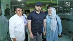 Ridho Rhoma (tengah) didampangi sang ayah, Rhoma Irama dan ibunya Ridho Marwah saat keluar dari RSKO, Jakarta, Kamis (25/01). Ridho Rhoma telah usai menjalankan rehabilitasi selama 10 bulan di RSKO. (Liputa6.com/Herman Zakharia)