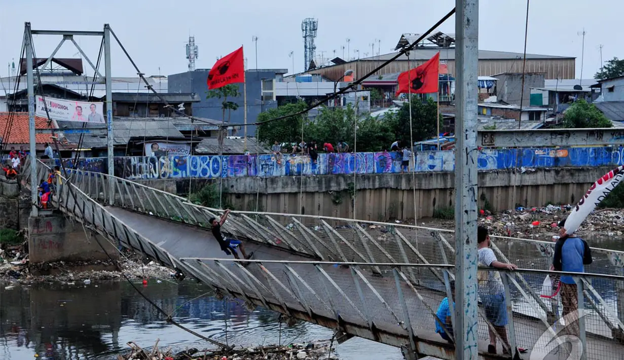 Jembatan gantung miring ke kiri karena salah satu bentangan kabel penyangga putus dan belum ada langkah perbaikan dari pemda DKI, Sabtu (14/06) (Liputan6.com/Andrian M Tunay)