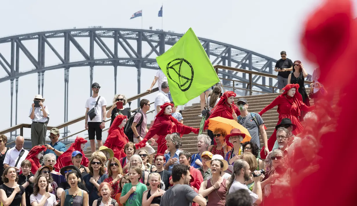 Aktivis yang terbagung dalam kelompok Red Rebels berunjuk rasa dalam demonstrasi protes iklim di Sydney (15/12/2019). Pengunjuk rasa melakukan aksi di depan landmark Gedung Opera Sydney menuntut pemerintah Australia menanggulangi asap yang menyebabkan masalah kesehatan. (AFP/Wendell Teodoro)