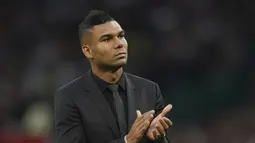 Pemain baru Manchester United Casemiro memberi tepuk tangan kepada para pendukung ketika diperkenalkan secara resmi sesaat sebelum laga MU vs Liverpool dimulai di stadion Old Trafford, Senin (22/8/2022). Casemiro pun duduk di tribun penonton, menyaksikan laga Man United vs Liverpool. (AP Photo/Dave Thompson)