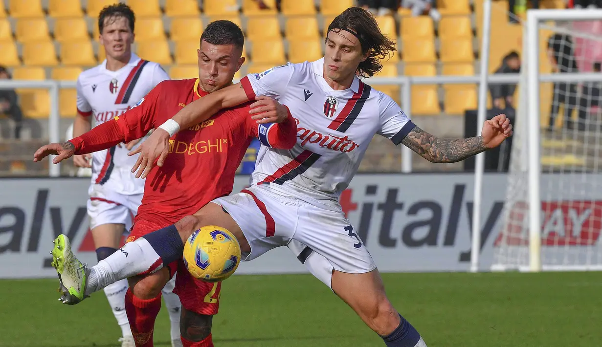 Pemain Lecce, Gabriel Strefezza (kiri) berebut bola dengan pemain Bologna, Riccardo Calafiori saat laga pekan ke-14 Liga Italia 2023/2024 di Via del Mare Stadium, Lecce, Italia, 3 Desember 2023 waktu setempat. Laga berakhir imbang dengan skor 1-1. (AP Photo/LaPresse/Giovanni Evangelista)