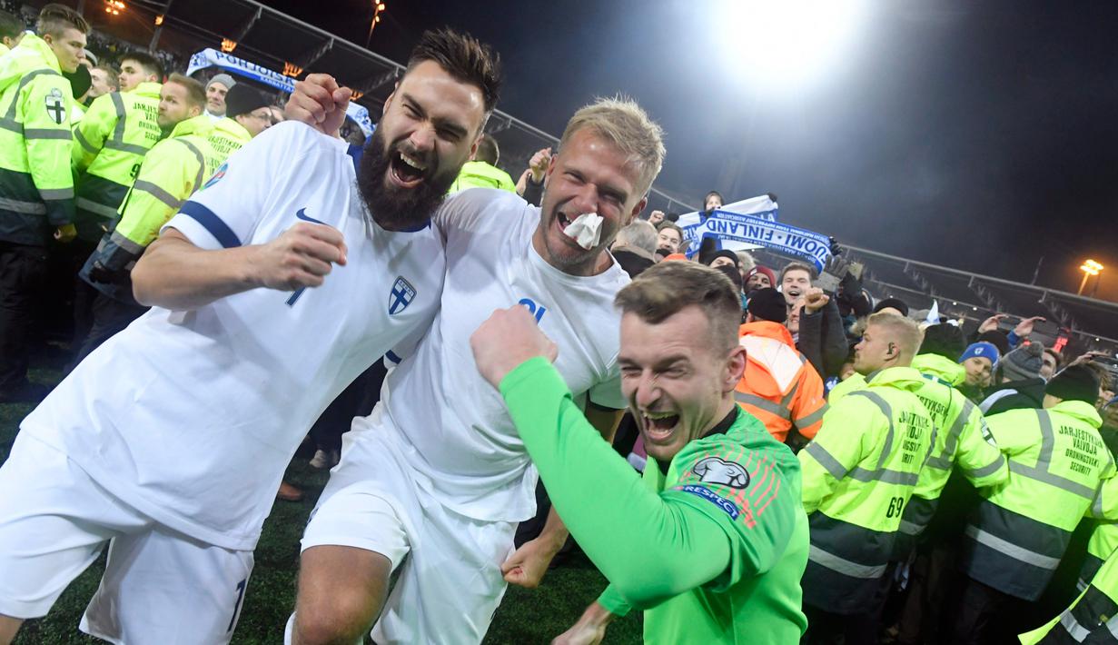 Pemain Finlandia Tim Sparv (kiri), Paulus Arajuuri (tengah), dan Lukas Hradecky (kanan) merayakan kemenangan mereka atas Liechtenstein pada babak kualifikasi Grup J Piala Eropa 2020 di Helsinki, Finlandia, Jumat (15/11/2019). Finlandia mencetak sejarah dengan lolos ke Piala Eropa. (Markku Ulander/Le