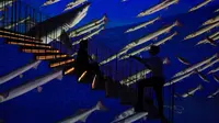 Seorang pria mengambil foto wanita berpose di galeri seni digital Infinity des Lumieres di Dubai Mall, Dubai, Uni Emirat Arab, Senin (12/7/2021). Infinity des Lumieres menggunakan proyektor digital untuk memutar gambar bergerak karya seni di galeri besar. (AP Photo/Jon Gambrell)