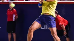 Petenis Spanyol, Rafael Nadal berusaha mengembalikan bola ke arah petenis Kanada, Denis Shapovalov pada turnamen Piala Rogers di Montreal, Kamis (10/8). Nadal disingkirkan petenis 18 tahun dengan skor 6-3, 4-6, 6-7. (MINAS PANAGIOTAKIS/GETTY IMAGES/AFP)
