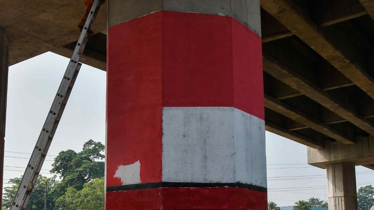 Petugas PPSU saat melakukan pemolesan tiang penyangga Tol Becakayu dengan cat warna putih merah pada tiang penyangga tol di kawasan Cipinang Besar Selatan.