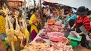 Seorang wanita membeli daging di sebuah pasar di Phnom Penh (24/7/2020). Pasar membentuk bagian integral dalam kehidupan orang Kamboja, dengan kunjungan harian yang dilakukan untuk persediaan makanan untuk hari itu serta barang-barang lainnya. (AFP/Tang Chhin Sothy)
