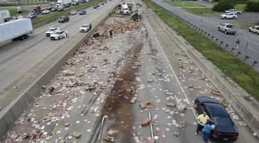 Ratusan pizza beku berserakan di Jalan Raya Arkansas, Amerika Serikat, 9 Agustus 2017. Kejadian disebabkan truk pembawa pizza beku dengan 18 roda kehilangan kendali setelah melintasi jembatan dan terbalik. (Arkansas Department of Transportation via AP)