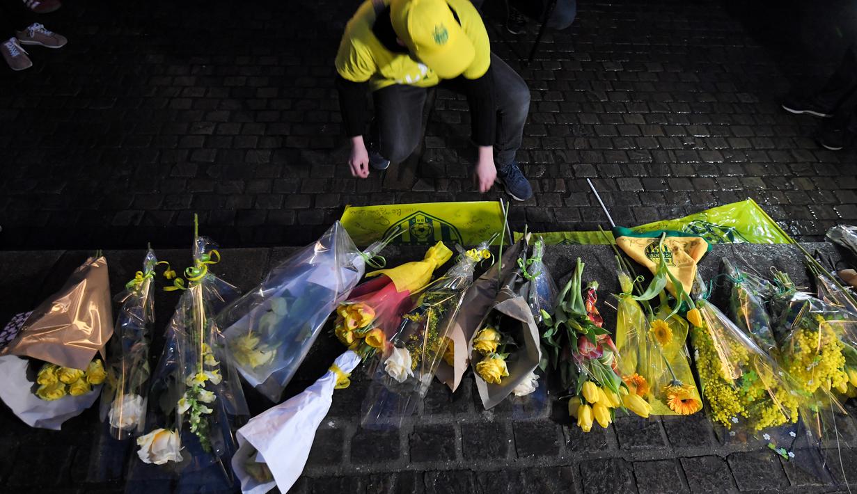 Ekspresi pendukung FC Nantes yang larut dalam kedukaan. Hal tersebut terjadi setelah mendengar kabar mantan bintang mereka, Emiliano Sala tewas karena pesawat yang ditumpanginya hilang dari kontak. (AFP/Loic Venance)