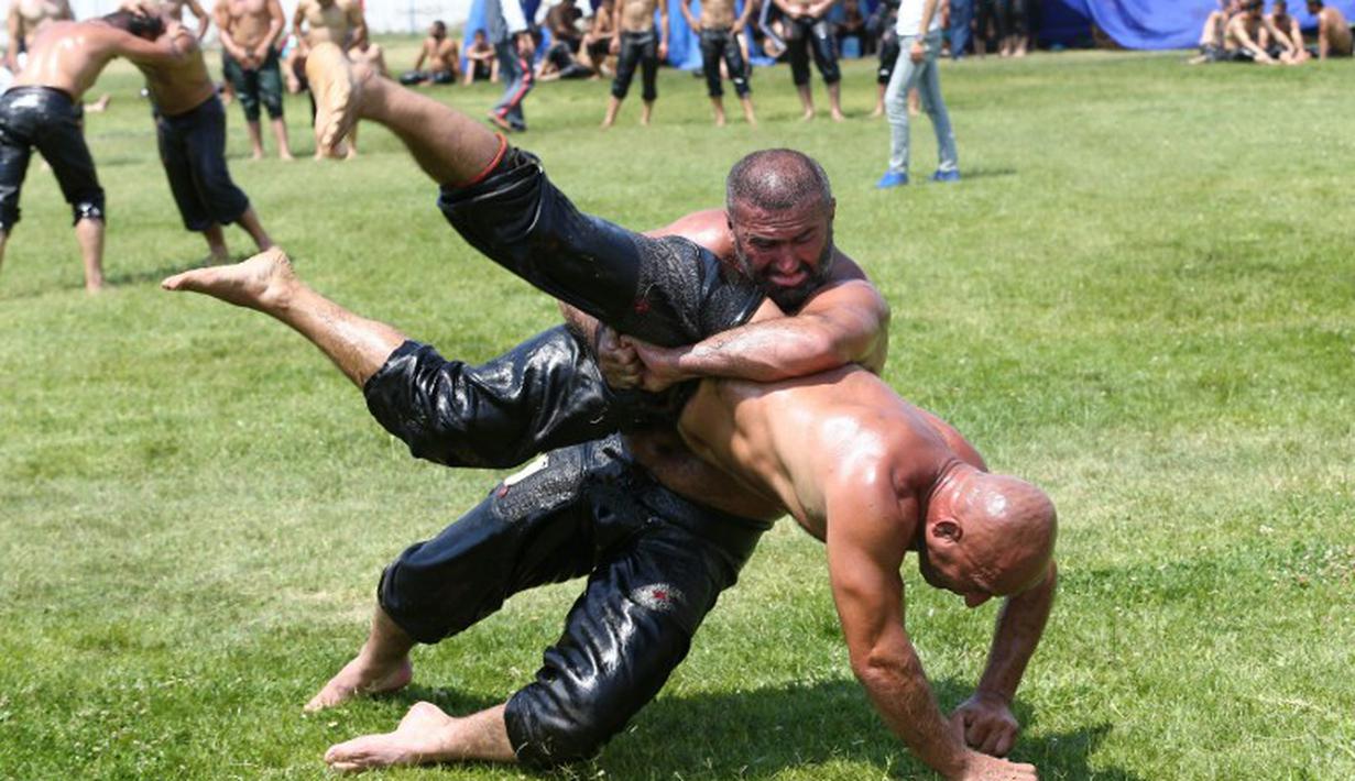 Oli yang di oleskan ke tubuh peserta menjadikan tubuh semakin licin. (AFP Photo/Adem Altan)