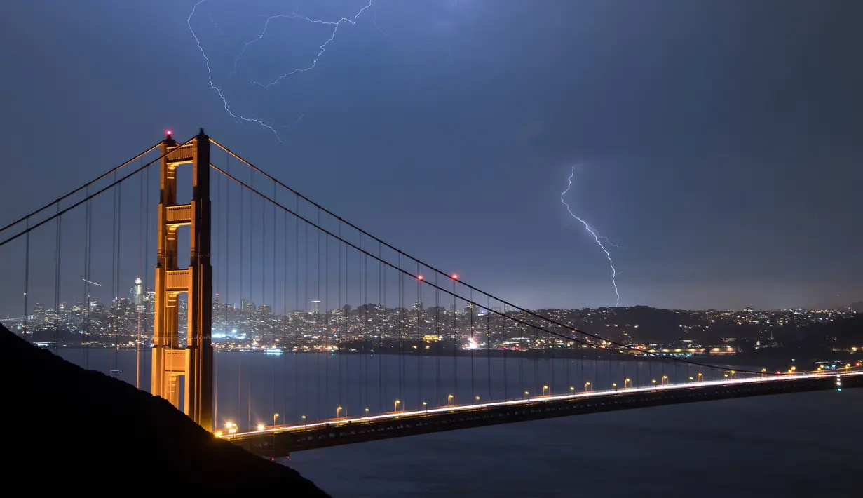 Suasana jembatan Golden Gate saat terjadi sambaran petir, San Francisco, California, AS (11/9). Petir merupakan Gejala alam yang biasanya muncul pada musim hujan di saat langit memunculkan kilatan cahaya sesaat yang menyilaukan. (AFP Photo/Josh Edelson)