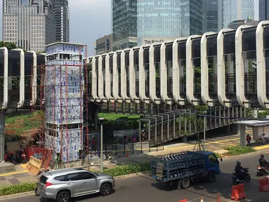 Suasana pembangunan lift pada jembatan penyeberangan orang di kawasan Senayan, Jakarta, Senin (13/5). Pembangunan lift pada tiga JPO yang berada di Jalan Sudirman itu bertujuan meningkatkan kenyamanan kepada warga dan ditargetkan rampung akhir bulan ini. (Liputan6.com/Immanuel Antonius)