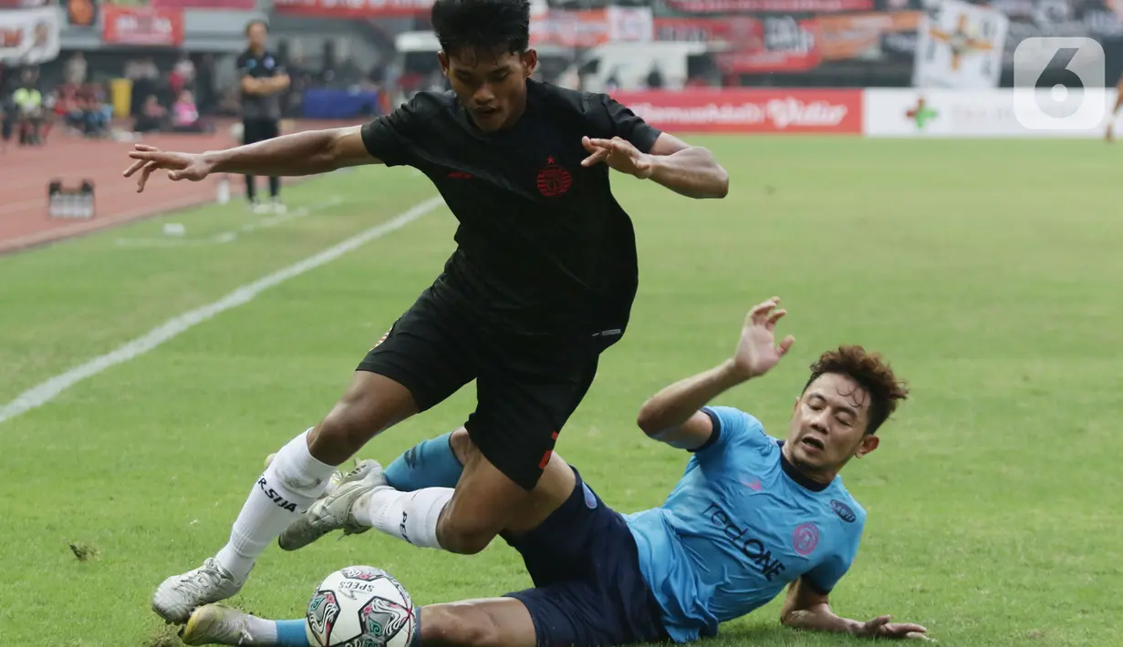 Pemain sayap Persija, Radzky Syahwal Ginting (kiri) mencoba melewati adangan pemain Sabah FC pada laga uji coba internasional di Stadion Patriot Candrabhaga, Kota Bekasi, Minggu (5/6/2022). Persija kalah 1-2 dari Sabah FC. (Liputan6.com/Helmi Fithriansyah)