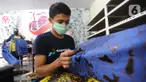 Perajin menyelesaikan proses pembuatan batik di  Batik Tradisiku, Bogor, Jawa Barat, Kamis (6/8/2020). Perajin batik mitra binaan Pertamina ini berinovasi dengan membuat motif dan warna baru untuk mengatasi anjloknya penjualan batik sebagai dampak ekonomi wabah corona. (merdeka.com/Arie Basuki)
