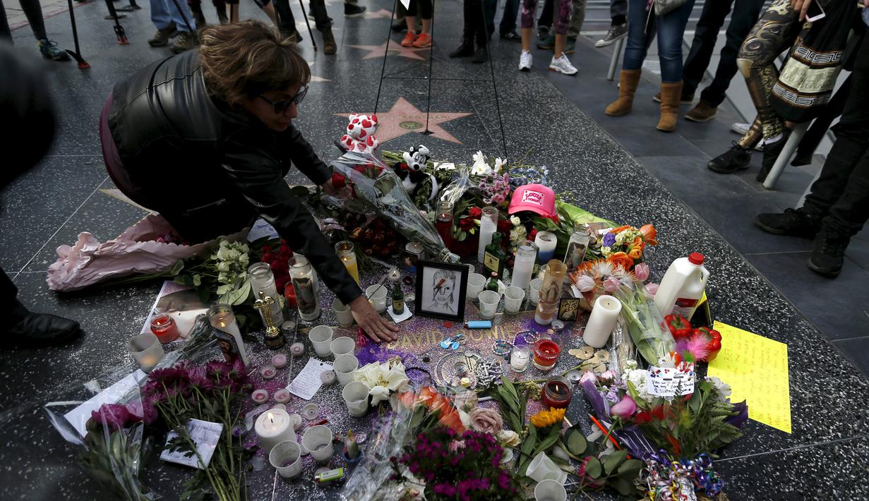 Penggemar meletakkan bunga di atas nama penyanyi legendaris David Bowie di Hollywood Walk of Fame di Los Angeles, Senin (11/1). Bowie meninggal di usianya yang ke 69 tahun dan baru saja merilis album ke-25 nya yaitu "Blackstar". (REUTERS/Mario Anzuoni)