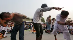 Sejumlah warga dalam keadaan kesurupan mengikuti Festival Tato Sihir di Wat Bang Phra, Bangkok, Thailand (19/3). Mereka percaya tato memiliki kekuatan mistis, menangkal nasib buruk dan melindungi mereka dari bahaya. (REUTERS/Chaiwat Subprasom)