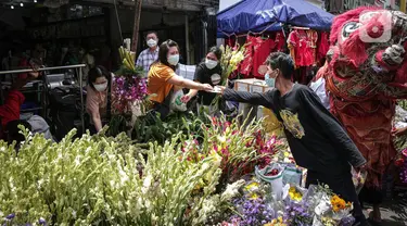 Penjual melayani pembeli bunga hias di Pasar Petak Sembilan, Glodok, Jakarta, Senin (31/1/2022). Jelang tahun baru Imlek 2573 sejumlah bunga seperti sedap malam, aster, mawar dan lainnya mulai banyak dicari warga Tionghoa untuk sembahyang. (Liputan6.com/Faizal Fanani)