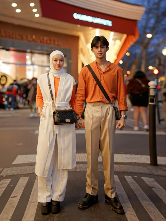 Kompak tampil dengan couple outfit, Dinda terlihat menggunakan blouse rajut yang dilapisi waistcoat dan celana kulot putih. [Foto: IG/rey_mbayang].