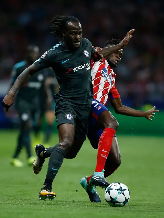 Gelandang Chelsea, Victor Moses membawa bola dari kawalan pemain Atletico Madrid, Thomas pada grup C Liga Champions di stadion Wanda Metropolitano, Spanyol, (27/9). Chelsea menang tipis 2-1 atas Atletico Madrid. (AP Photo / Paul White)