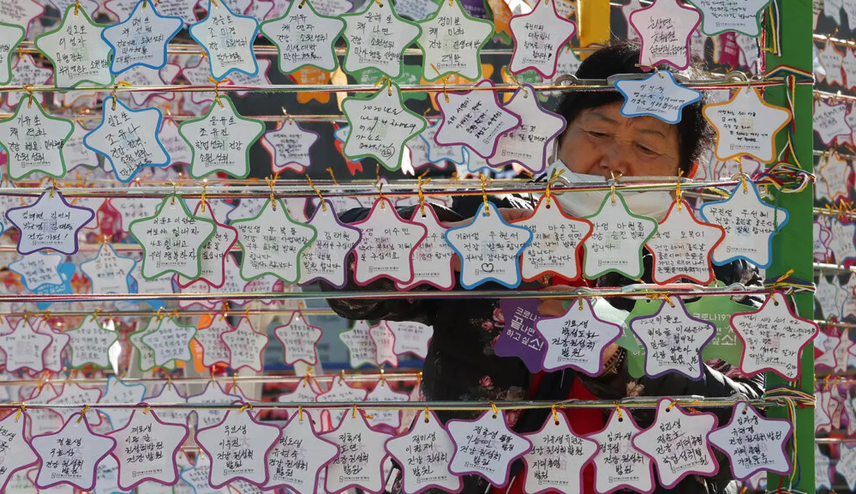 Seorang wanita menggantungkan kertas berisi doa keberhasilan untuk anaknya dalam ujian masuk perguruan tinggi di Kuil Buddha Jogyesa, Seoul, Korea Selatan, Kamis (3/12/2020). Ujian diikuti ratusan ribu siswa, termasuk puluhan siswa pasien COVID-19. (AP Photo/Ahn Young-joon)