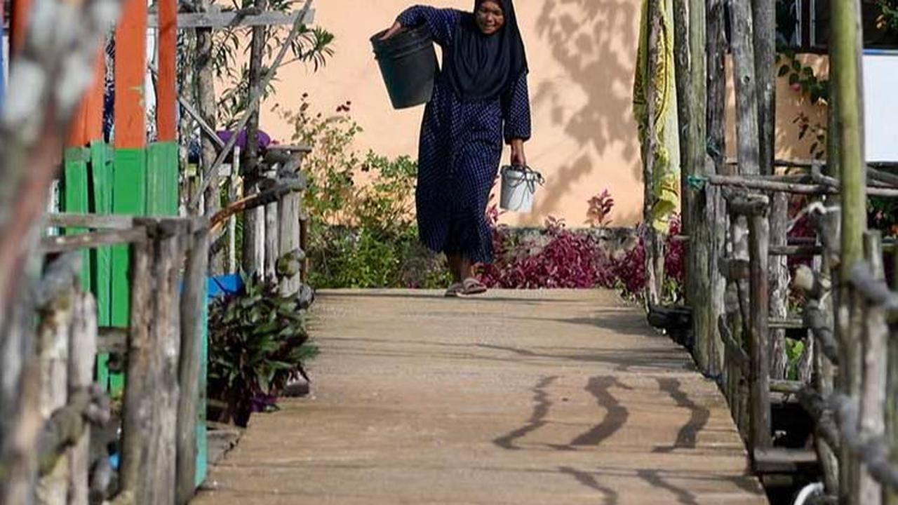 Seorang perempuan berjalan di Desa Monggak di Pulau Rempang.