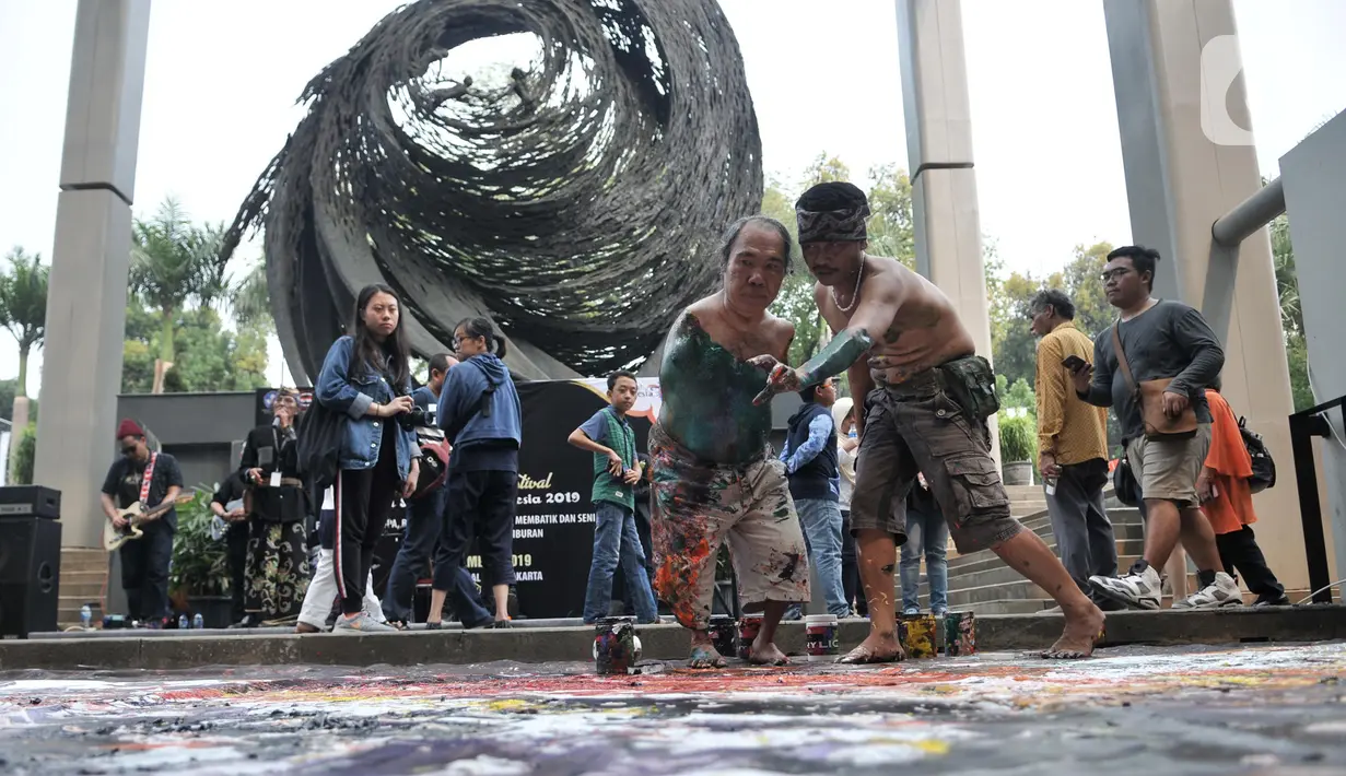 Sadikin Pard (53) membuat karya lukisan dengan kedua kakinya saat Indonesian Art Festival di Museum Nasional, Jakarta, Minggu (10/11/2019). AMFPA merupakan organisasi yang menghimpun seniman yang melukis menggunakan kaki atau mulut. (merdeka.com/Iqbal S. Nugroho)