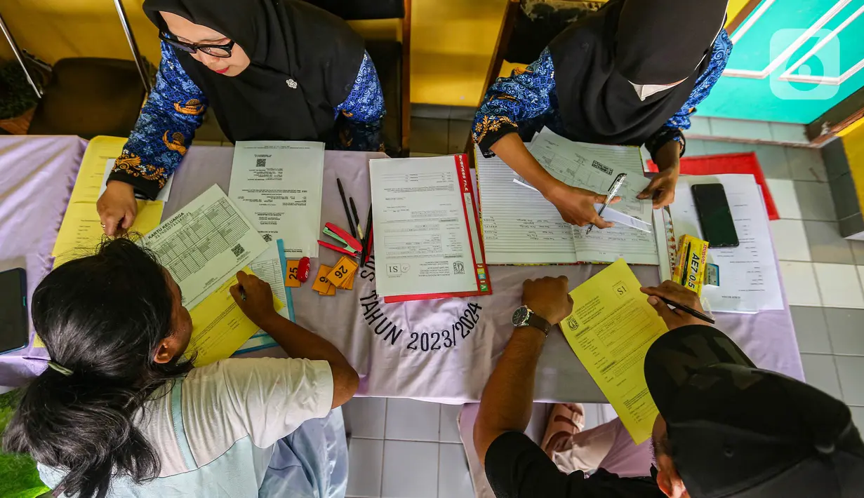 Petugas melayani orang tua calon peserta didik saat pendaftaraan Penerimaan Peserta Didik Baru (PPDB) di SD Grogol Selatan 08, Jakarta, Senin (20/5/2024). (Liputan6.com/Angga Yuniar)