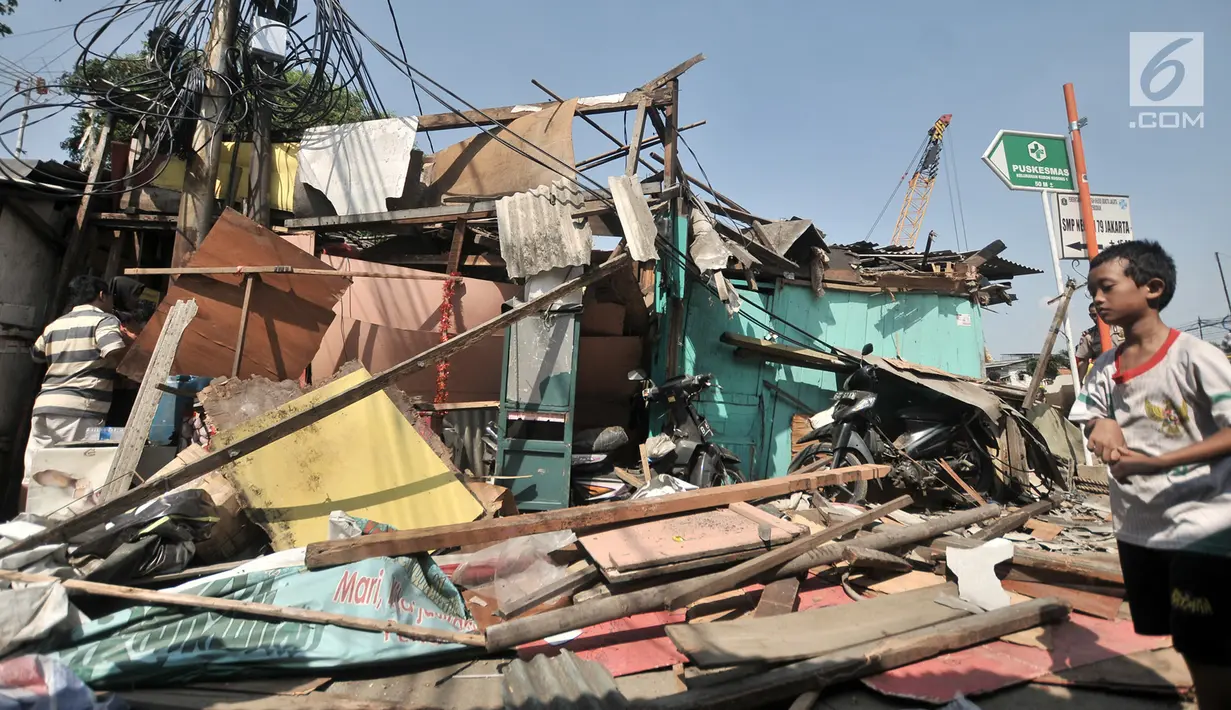 Anak pemilik rumah memindahkan barang pasca rumah ambruk akibat tertimpa crane yang jatuh di kawasan Kemayoran, Jakarta, Kamis (6/12). Akibat kejidan tersebut menyebabkan tiga orang luka-luka. (Merdeka.com/Iqbal S. Nugroho)