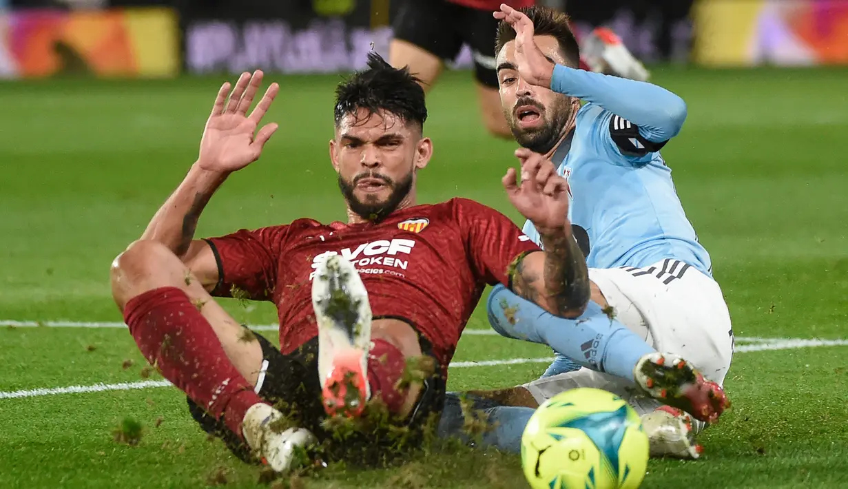 Pemain Valencia Omar Alderete (kiri) berebut bola dengan pemain Celta Vigo Brais Mendez pada pertandingan Liga Spanyol di Stadion Balaidos, Vigo, Spanyol, 5 Desember 2021. Valencia menang 2-1. (MIGUEL RIOPA/AFP)