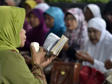 Seorang wanita tampak memimpin doa di depan gedung KPK, Jakarta, Rabu (17/6/2015). Mereka mendoakan Mantan Menteri Agama Suryadharma Ali agar mendapatkan penangguhan penahanan. (Liputan6.com/Helmi Afandi)