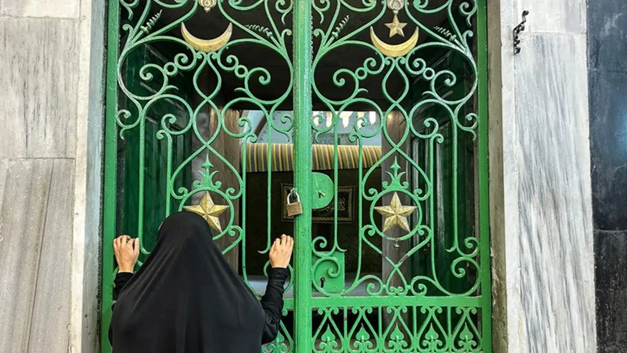 Seorang perempuan memandang Masjid Ibrahimi melalui gerbang besi di Kota Hebron, Tepi Barat yang diduduki, pada 16 Juni 2026.