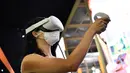 Seorang wanita mencoba kacamata virtual reality di stan Orange selama pameran Mobile World Congress (MWC) di Barcelona (28/6/2021). (AFP/Pau Barrena)