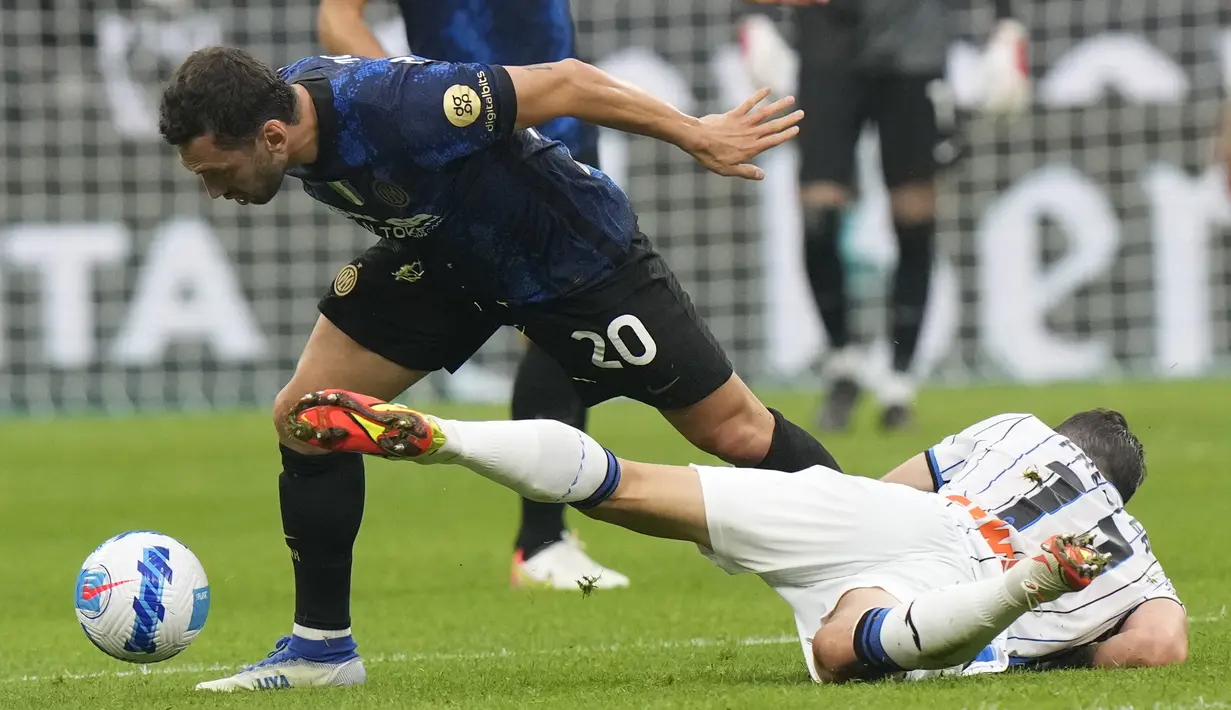 Gelandang Inter Milan Hakan Calhanoglu melompat untuk mendapatkan bola dengan gelandang Atalanta Remo Freuler pada jornada keenam Liga Italia 2021/2022 di Giuseppe Meazza, Sabtu (25/9/2021). Duel antara Inter Milan dan Atalanta berakhir seri 2-2. (AP Photo/Luca Bruno)