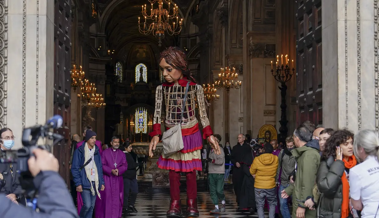 Boneka raksasa Little Amal tiba di Katedral St Paul, di London, Inggris, Sabtu (23/10/2021). Kedatangan Little Amal di kota London, Inggris, disambut ratusan warga pada Sabtu (23/10) waktu setempat. (AP Photo/Alberto Pezzali)